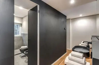 a bathroom with a toilet and a black wall at Vicolo Orsoline Piazza Spagna in Rome