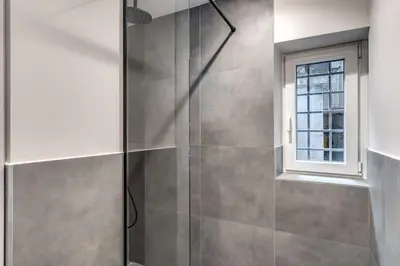 a shower with a glass door and a window at Vicolo Orsoline Piazza Spagna in Rome