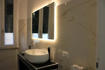a bathroom with a white sink and a mirror at Alicemaria Vatican Comfortable Apartment in Rome