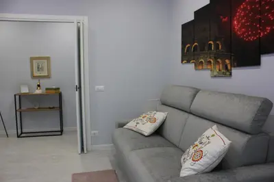 a living room with a gray couch with two pillows at Alicemaria Vatican Comfortable Apartment in Rome