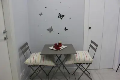 a table with chairs and a plate of food on it at Alicemaria Vatican Comfortable Apartment in Rome