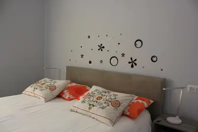 a bedroom with a bed with clocks on the wall at Alicemaria Vatican Comfortable Apartment in Rome