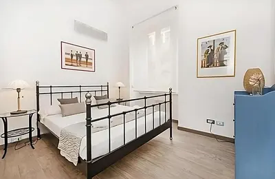 a bedroom with a black and white bed and a table at Ungaretti Vatican Apartment in Rome
