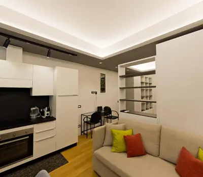 a living room with a couch and a kitchen at Appartamento Appia metro A Colli Albani in Rome