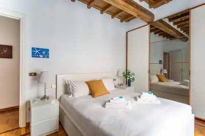 a bedroom with a large white bed and a mirror at iFlat Classy & Spacious apt near Campo de Fiori in Rome