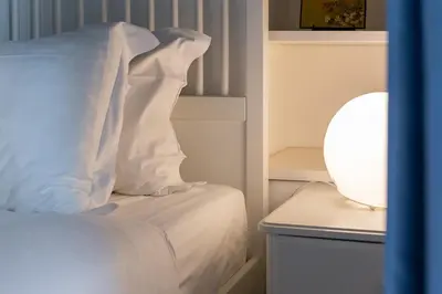 a white bed with a white pillow and a lamp at iFlat Classy & Spacious apt near Campo de Fiori in Rome