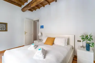 a bedroom with a white bed with two shoes on it at iFlat Classy & Spacious apt near Campo de Fiori in Rome