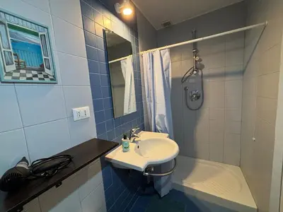 a blue and white bathroom with a sink and a shower at Roma, Città degli Uomini in Rome