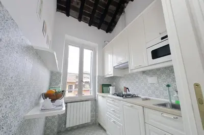 a small kitchen with white cabinets and a window at Montevecchio2 in Rome