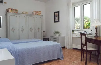 a bedroom with two beds and a desk and a dresser at Soggiorni Romani in Rome