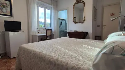 a bedroom with a bed and a television and a mirror at Soggiorni Romani in Rome