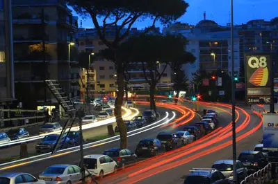 a busy city street filled with cars at night at Soggiorni Romani in Rome