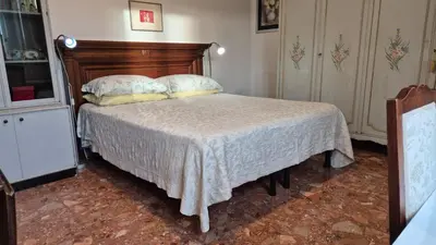 a bedroom with a bed with a wooden headboard at Soggiorni Romani in Rome