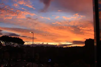 a sunset in a city with a cloudy sky at Soggiorni Romani in Rome