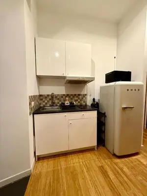 a kitchen with white cabinets and a refrigerator at Monti Cozy Apartment in Rome