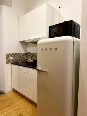 a kitchen with a silver refrigerator with a microwave on top at Monti Cozy Apartment in Rome