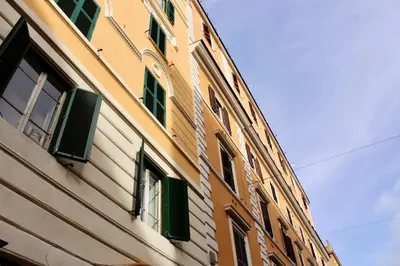 a building with green shutters on the side of it at HC - Miriam's Brand New Apartment in Vatican in Rome
