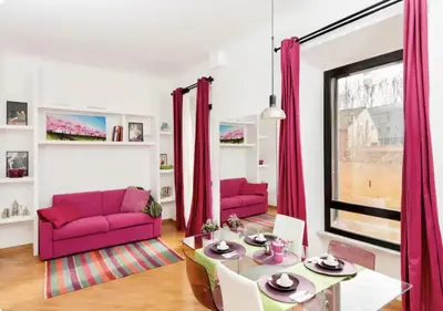 a living room with a pink couch and a table at LoL-ApartmenT, in the heart of Trastevere in Rome