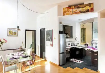 a kitchen with a stainless steel refrigerator and a table at LoL-ApartmenT, in the heart of Trastevere in Rome