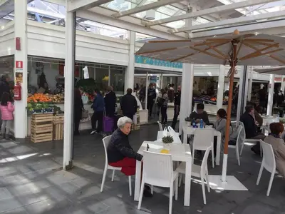 an older woman sitting at a table at a market at Casa Aventino in Rome