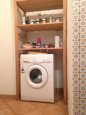 a laundry room with a washing machine in a shelf at Casa Aventino in Rome