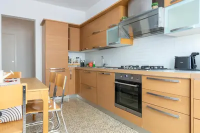 a kitchen with wooden cabinets and a table and a stove at Family Rooms in Rome