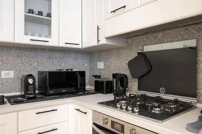 a kitchen with a stove top oven next to a microwave at Residenza Gradinata al Vaticano in Rome