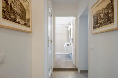 a hallway with white walls and paintings on the walls at Residenza Gradinata al Vaticano in Rome