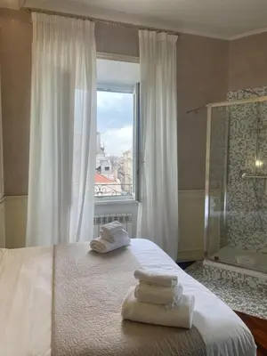 a bedroom with a bed and a window with towels on it at Rome Opera Theatre Rooms by Dama - Termini Station & Rome City Center in Rome