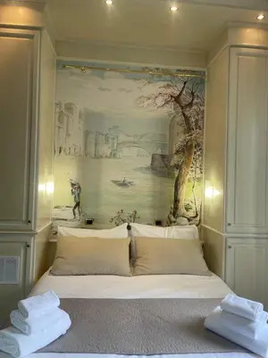 a bedroom with a painting on the wall above a bed at Rome Opera Theatre Rooms by Dama - Termini Station & Rome City Center in Rome