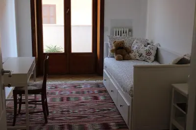 a teddy bear sitting on a bed in a bedroom at Dodo's luxury house in Santa Maria Maggiore in Rome