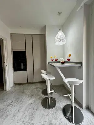 a kitchen with two stools and a table with wine glasses at Dodo's luxury house in Santa Maria Maggiore in Rome