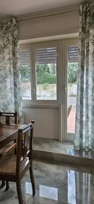 a dining room with two windows and a wooden table at Anastasio Terrace double 3 in Rome