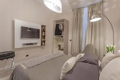 a bedroom with a bed and a tv on the wall at St. George's Vatican Suites in Rome