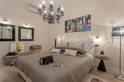 a bedroom with a large bed and a chandelier at St. George's Vatican Suites in Rome
