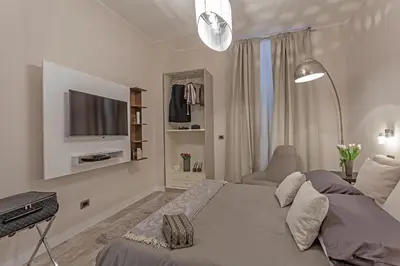 a white bedroom with a bed and a television at St. George's Vatican Suites in Rome