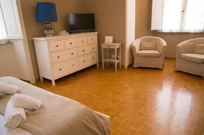 a bedroom with two beds and a television and a chair at Amalia Vatican House in Rome
