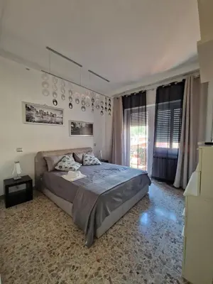 a bedroom with a large bed and a large window at Domus Roma Apartment in Rome