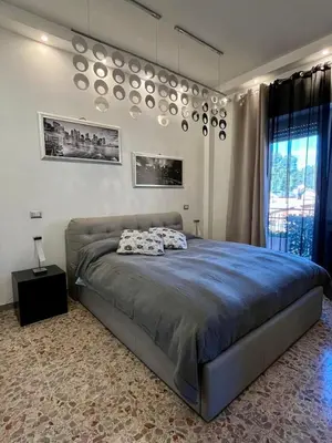 a bedroom with a large bed and a chandelier at Domus Roma Apartment in Rome