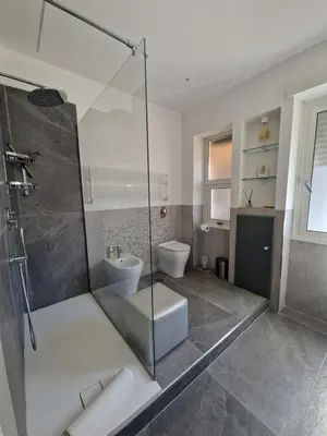 a bathroom with a glass shower and a toilet at Domus Roma Apartment in Rome