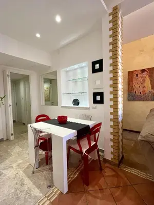a dining room with a white table and red chairs at Domus Roma Apartment in Rome