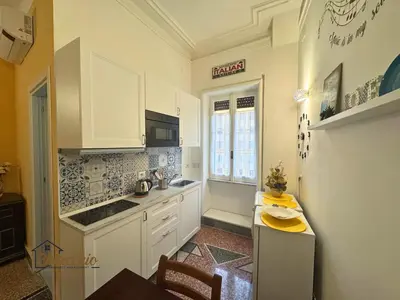a kitchen with white cabinets and a table and a window at Satrico43 - San Giovanni Stay in Rome