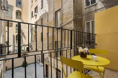 a yellow table and chairs on a balcony at Visconti58 Boutique House - Modern apt with balcony in Rome
