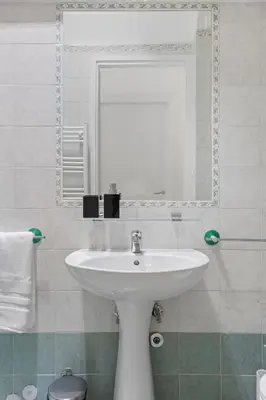 a bathroom with a white sink and a mirror at Visconti58 Boutique House - Modern apt with balcony in Rome