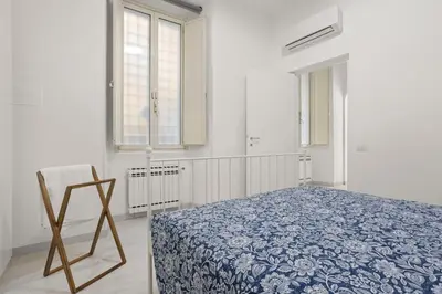 a bedroom with a bed and a chair in it at Visconti58 Boutique House - Modern apt with balcony in Rome