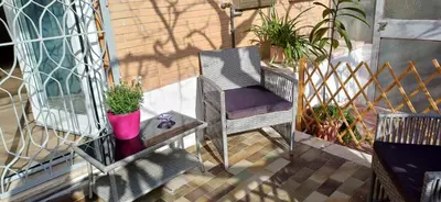 a balcony with a chair and potted plants on it at Il giardino dell'Eden 10 - Alloggio Turistico in Rome