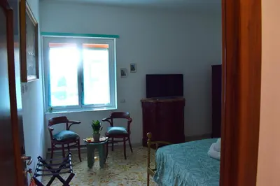 a bedroom with a bed and chairs and a window at Il giardino dell'Eden 10 - Alloggio Turistico in Rome