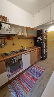 a kitchen with a stove and a rug on the floor at Peck House in Marconi San Paolo in Rome