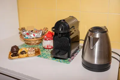 a coffee maker and a plate of donuts on a counter at Peck House in Marconi San Paolo in Rome
