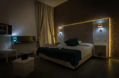 a hotel room with a large bed and a bathroom at Elenoire Rooms & Suite in Rome